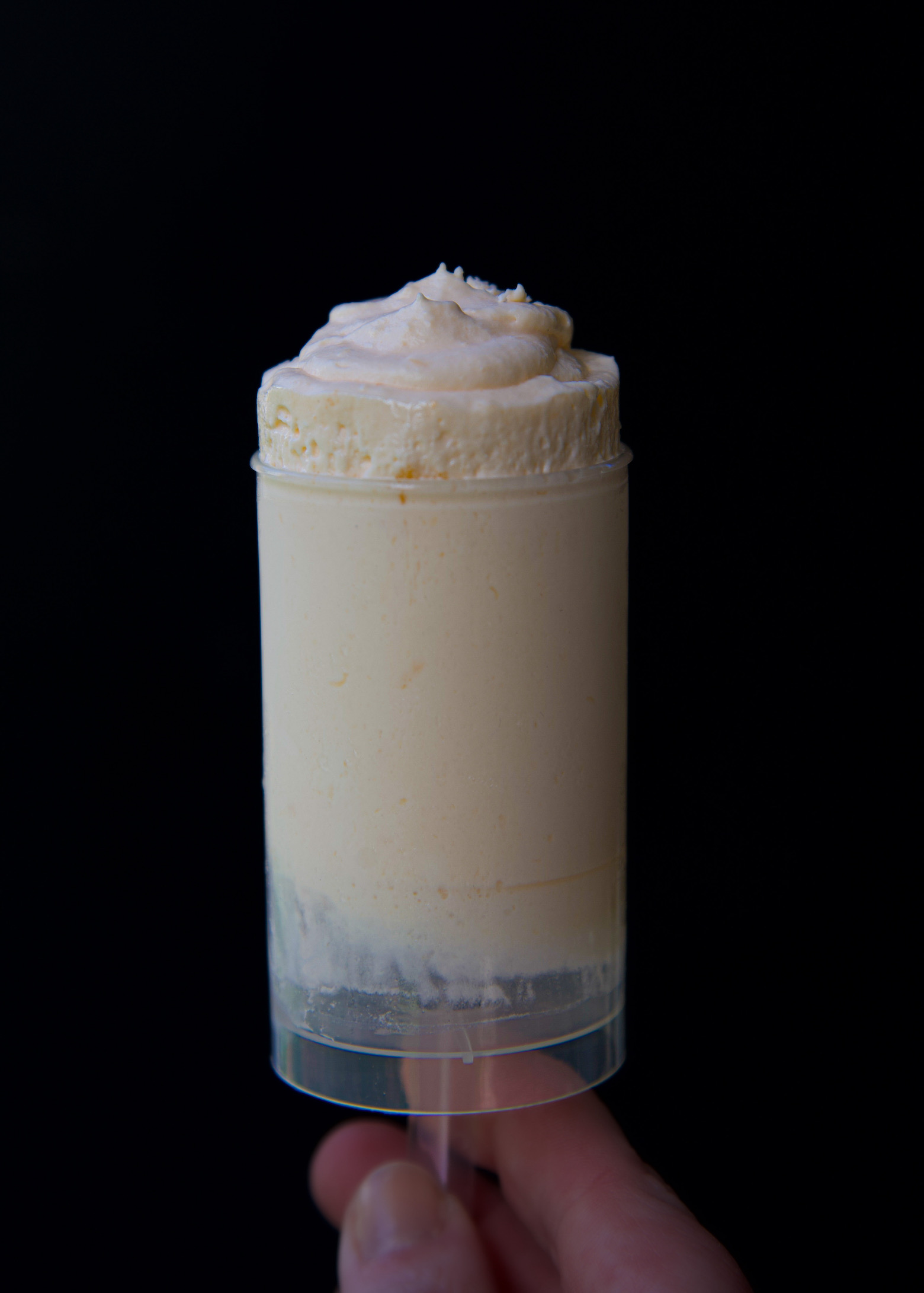 Single Creamsicle Bavarian Cream Push Pop being pushed up to show the filling. 