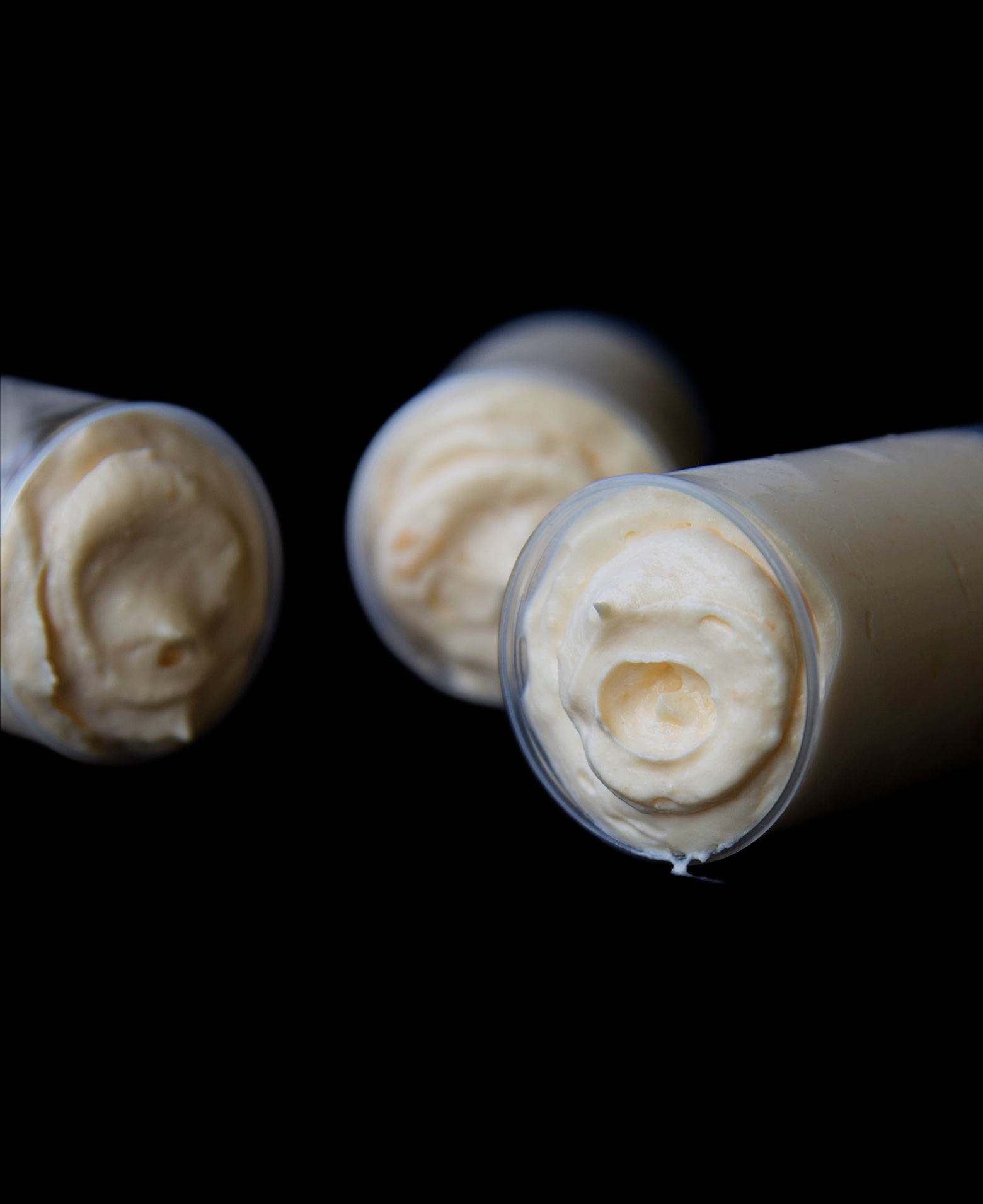 Three Creamsicle Bavarian Cream Push Pops on their side exposing the tops. 