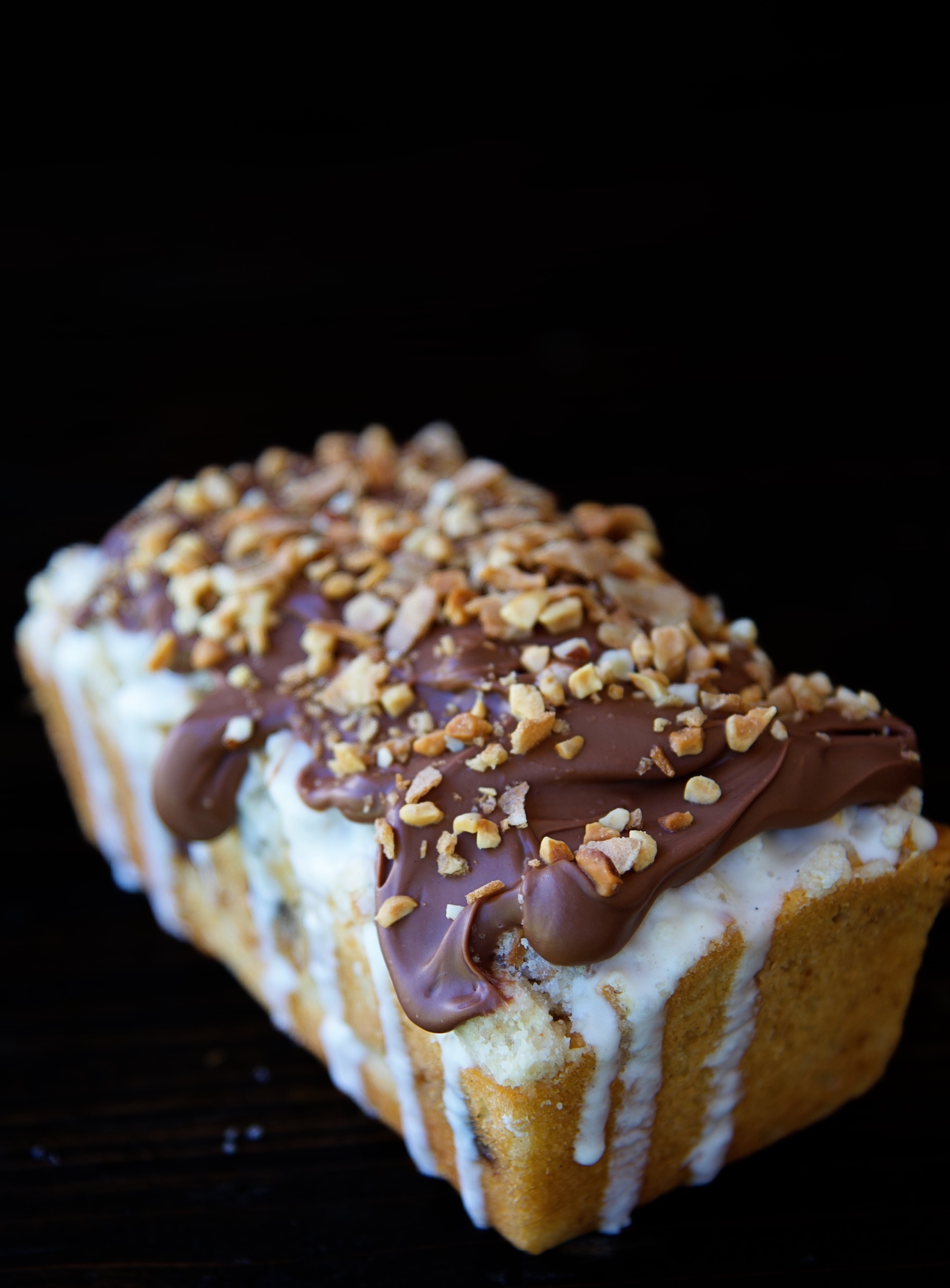 Single Glazed Drumstick Crumb Cake with a close up of the corner of chocolate on top of the vanilla glaze. 