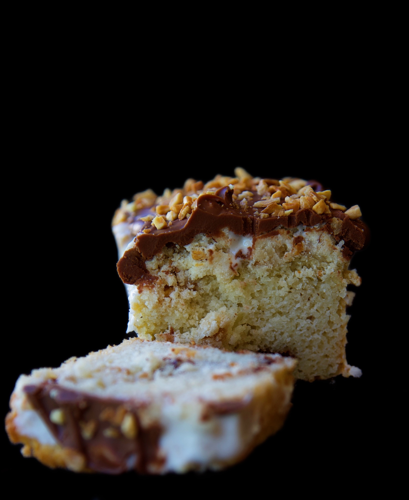 Side view of sliced crumb cake with a slice by the side. Focus on the center of the crumb cake. 