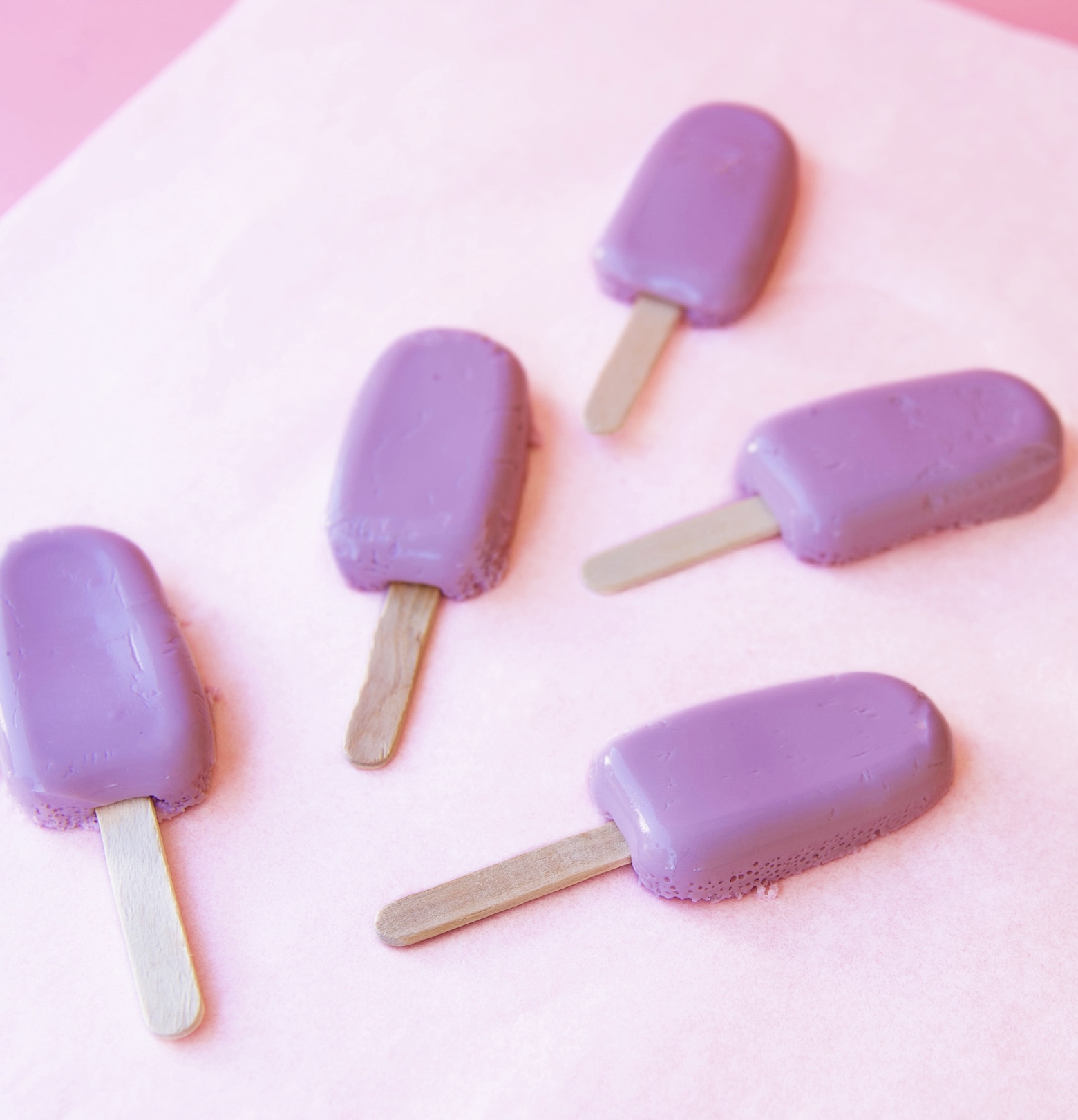 Five Grape Popsicle Jello Molds in mini popsicle mold shape with popsicle sticks coming out of them. 