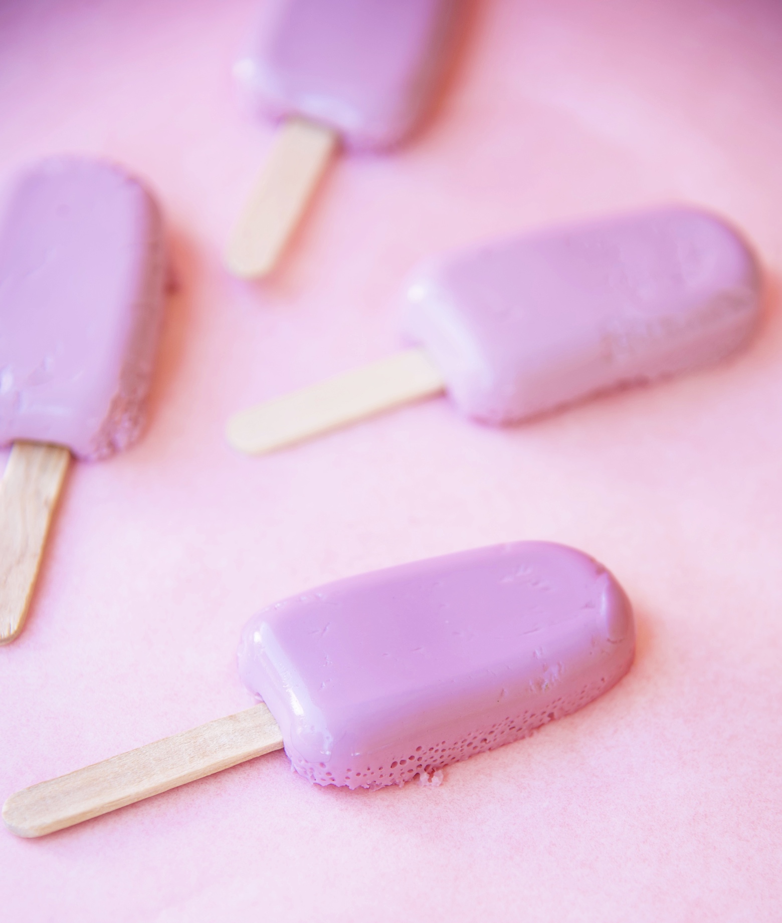 Grape Popsicle Jello in mini popsicle mold shape with popsicle sticks coming out of them. 