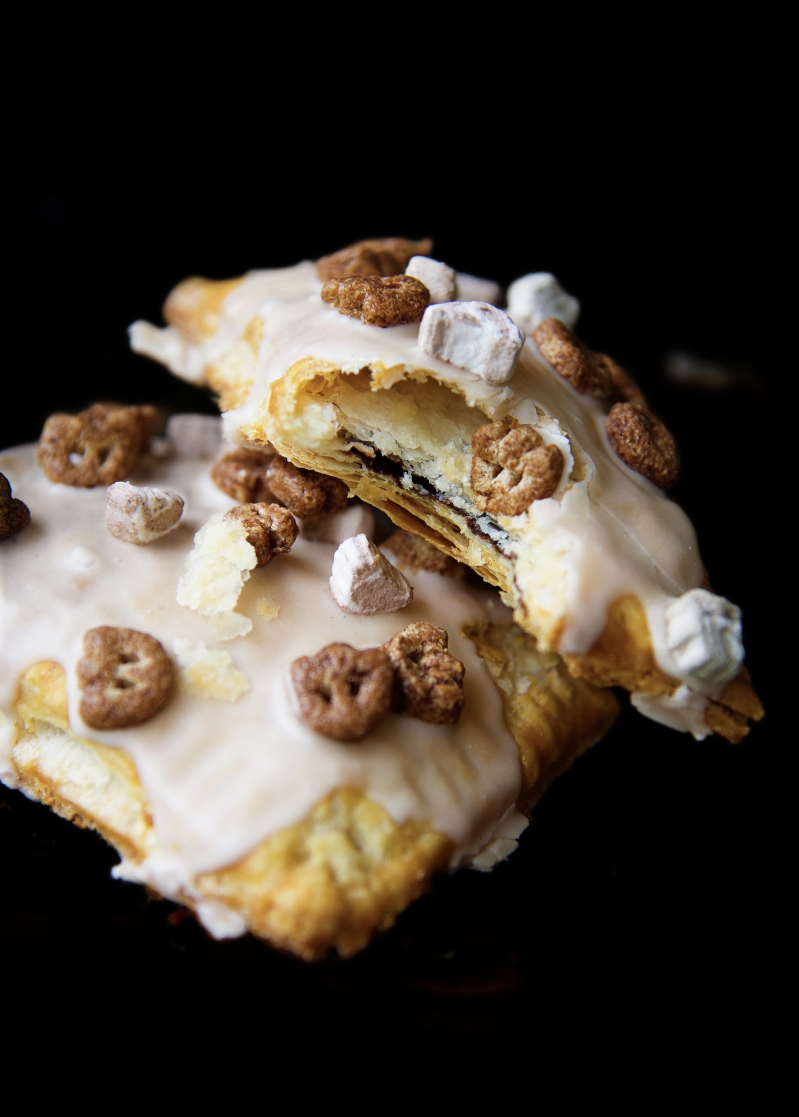 Two Count Chocula Pop Tarts stacked on top of each other. One pop tart has a bite out of it exposing the filling. 