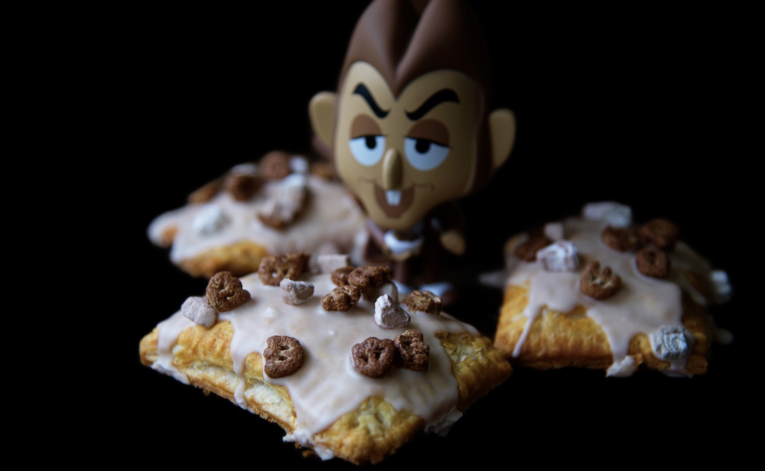 Count Chocula figurine surrounded by three frosted Count Chocula Pop Tarts 