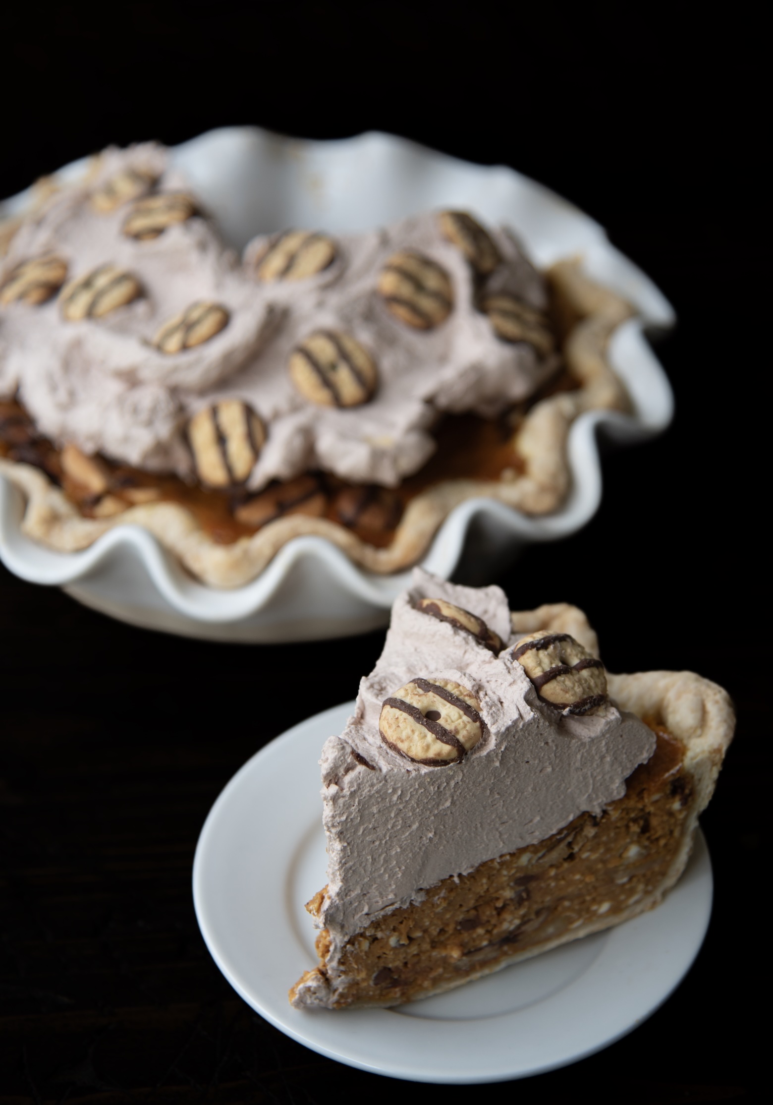 Slice of Fudge Cookie Pumpkin Pie in front of the remaining pie in background. 