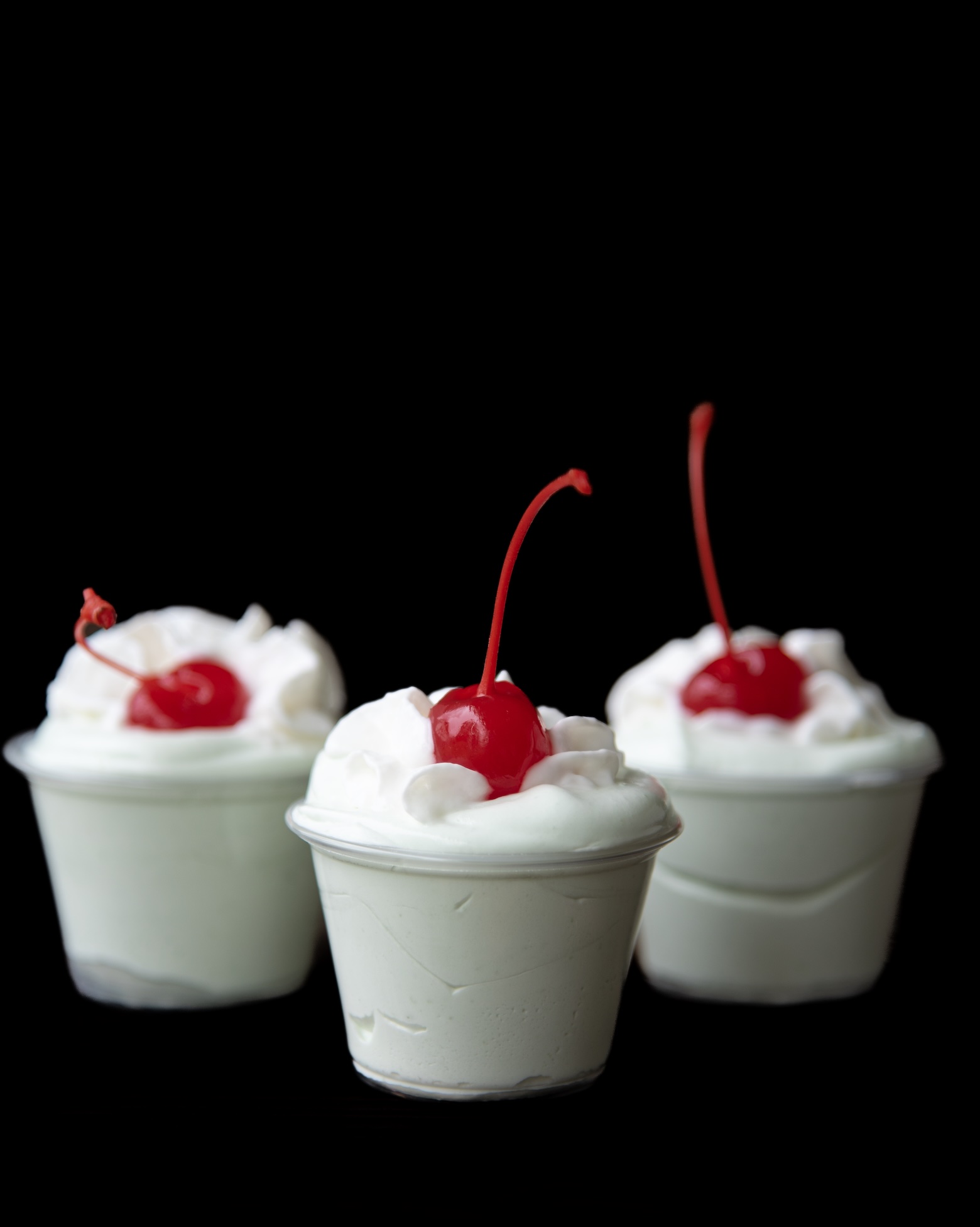 Side view of three Shamrock Shake Pudding Shots with the focus on the middle shot. 