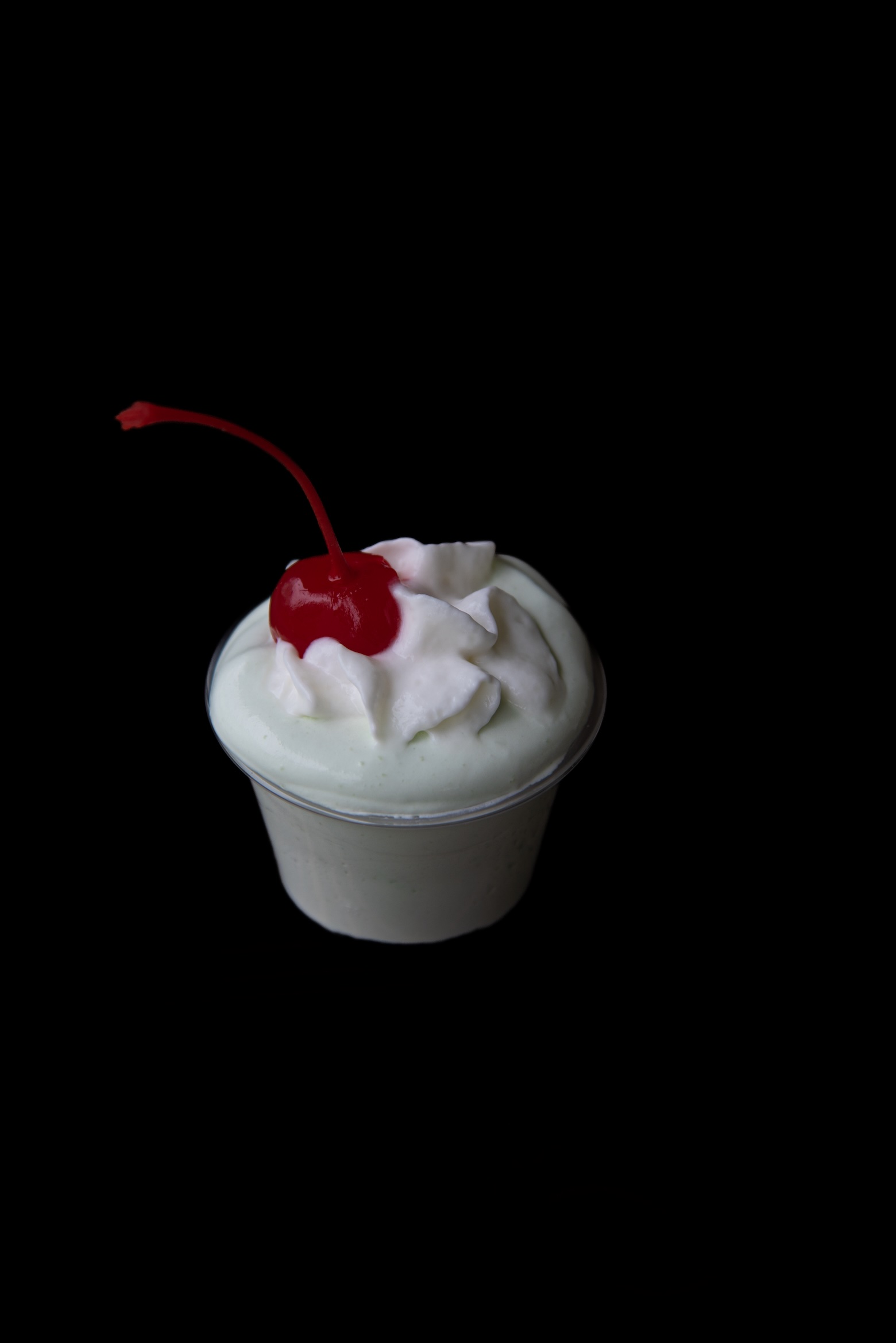 Single Shamrock Shake Pudding Shot with a focus on the cherry